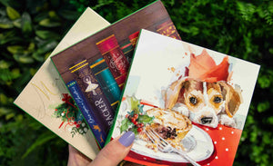 Selection of Woodgreen's Christmas cards being held in a person's hand